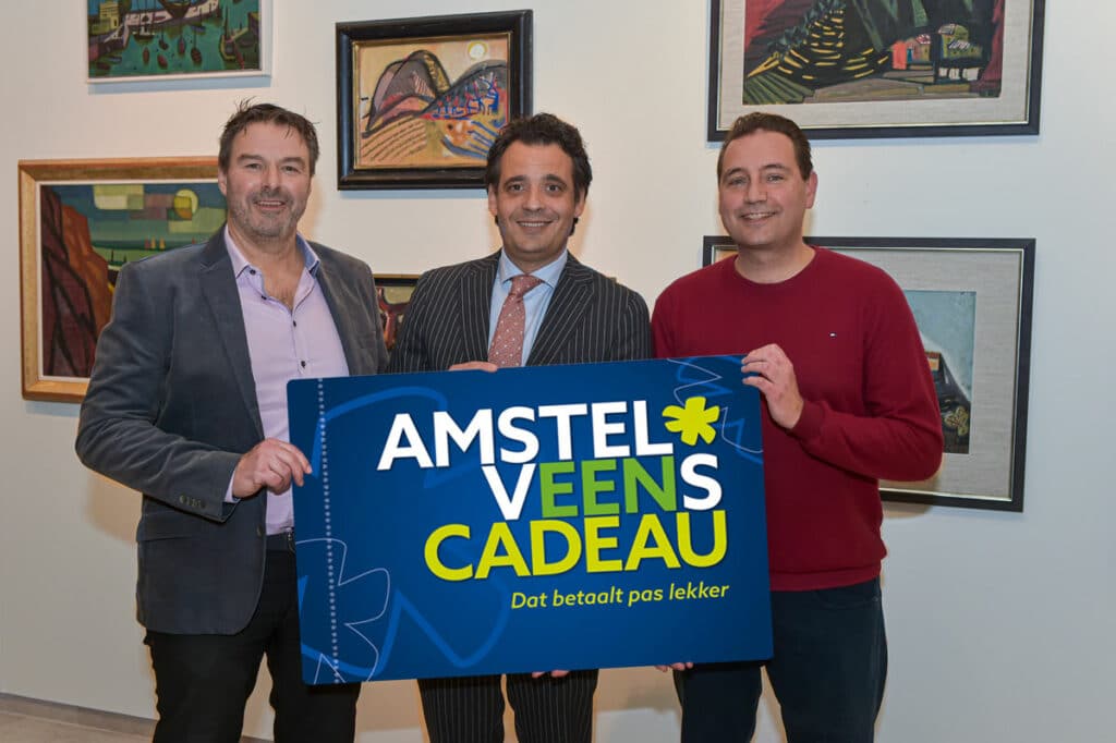 John Keunen en wethouder Adam Elzakalai met het Amstelveens Cadeau